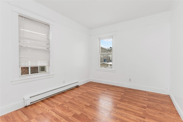 spare room featuring a baseboard radiator and wood-type flooring