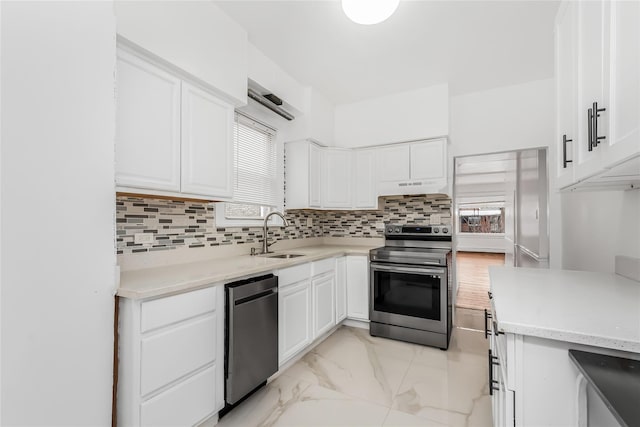 kitchen with tasteful backsplash, sink, white cabinets, and electric stove