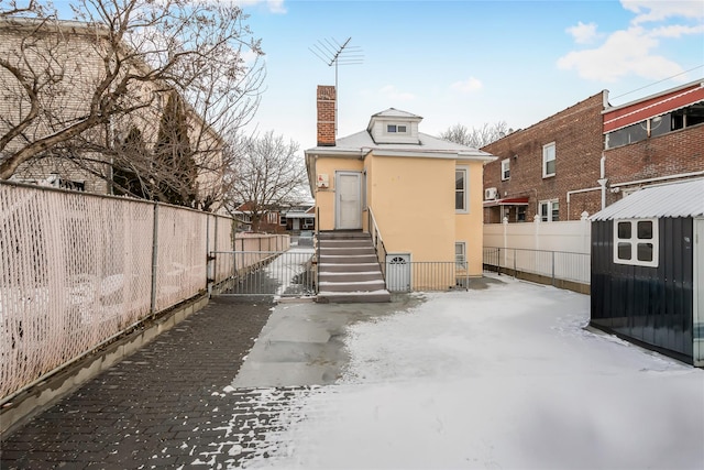 view of snow covered rear of property