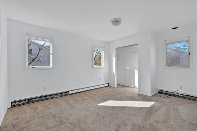 empty room with a baseboard radiator and light colored carpet