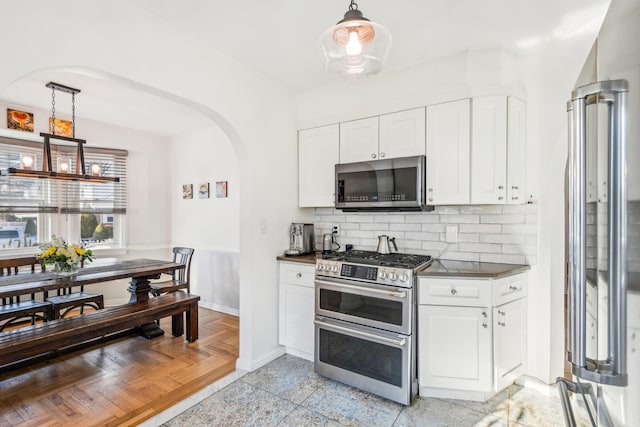 kitchen with white cabinetry, hanging light fixtures, tasteful backsplash, and stainless steel appliances