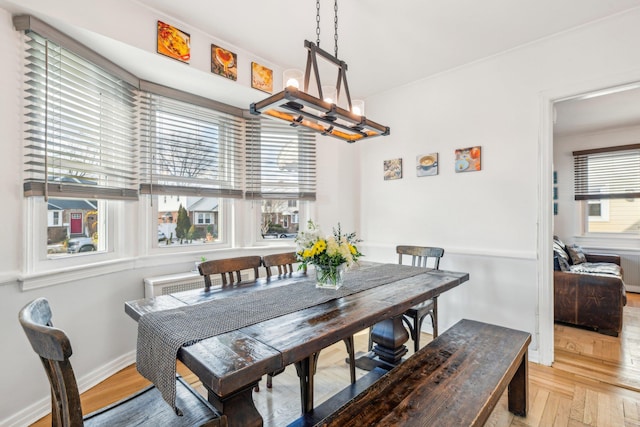 dining room featuring plenty of natural light, light parquet flooring, and a chandelier