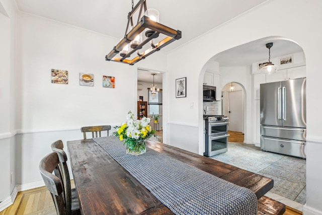 dining space featuring ornamental molding and a notable chandelier