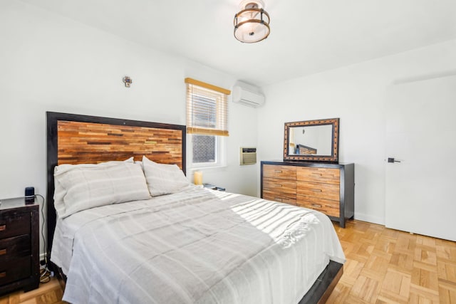 bedroom featuring light parquet flooring and an AC wall unit