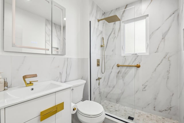 bathroom featuring vanity, toilet, tile walls, and a tile shower