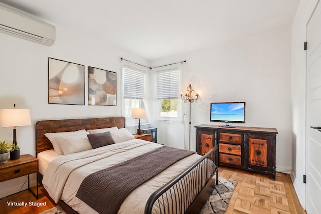 bedroom with light parquet floors and a wall mounted AC