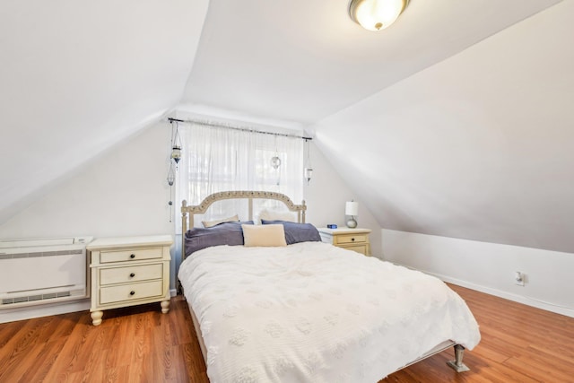 bedroom featuring wood-type flooring and vaulted ceiling