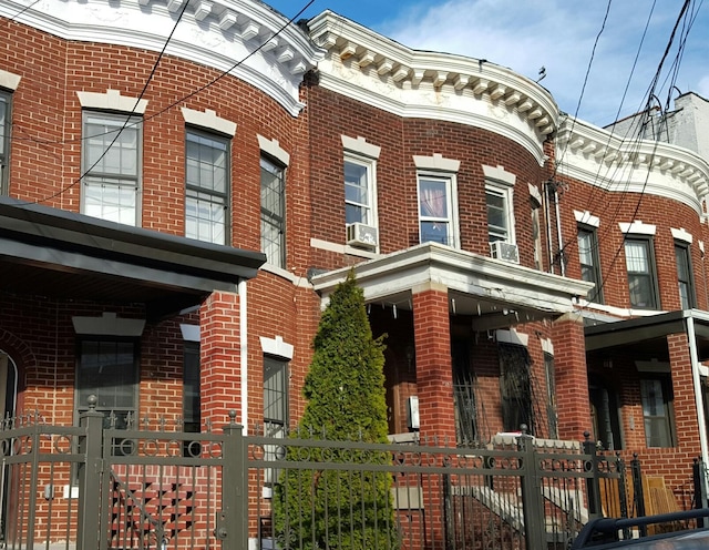 view of front of home with brick siding and fence