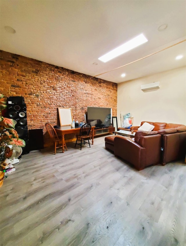 living area with brick wall, wood finished floors, and a wall mounted AC