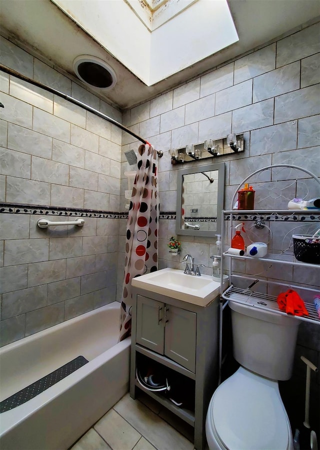 bathroom featuring tasteful backsplash, toilet, tile patterned floors, vanity, and tile walls