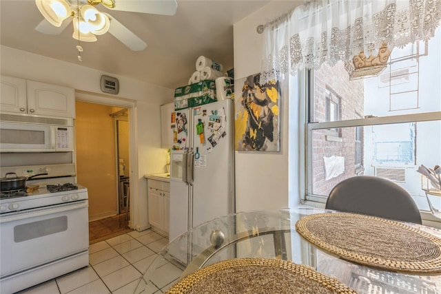 kitchen featuring ceiling fan, white appliances, light tile patterned floors, and white cabinets