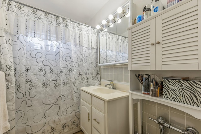 bathroom featuring vanity, tile walls, walk in shower, and decorative backsplash