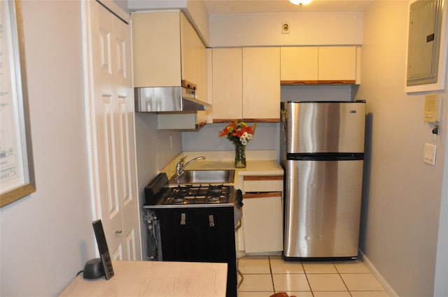 kitchen featuring stainless steel fridge, electric panel, sink, and light tile patterned floors