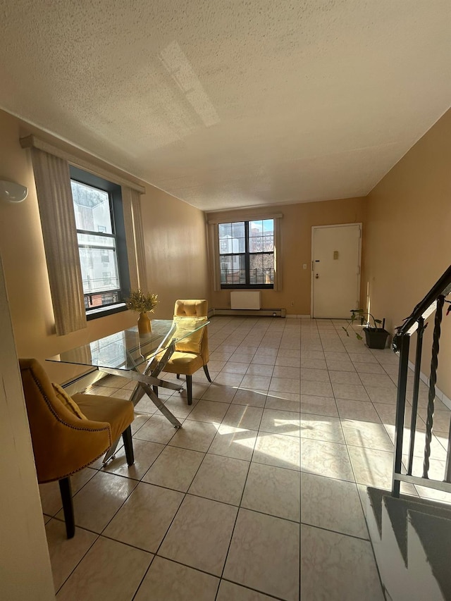 unfurnished room with plenty of natural light, light tile patterned floors, and a textured ceiling