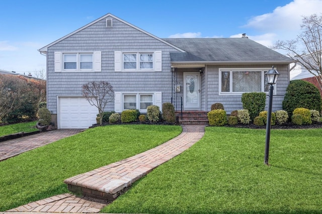 split level home with a garage and a front lawn