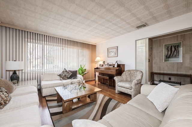 living room with crown molding and wood-type flooring