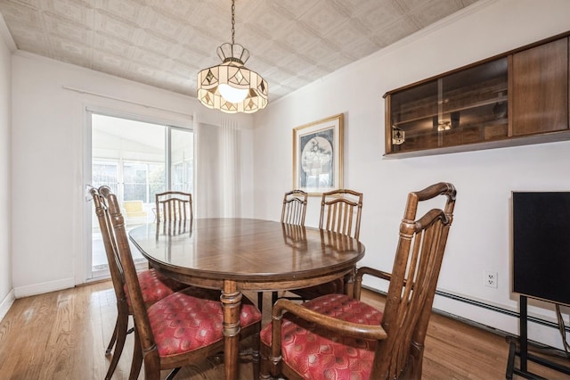 dining room featuring ornamental molding and light wood-type flooring