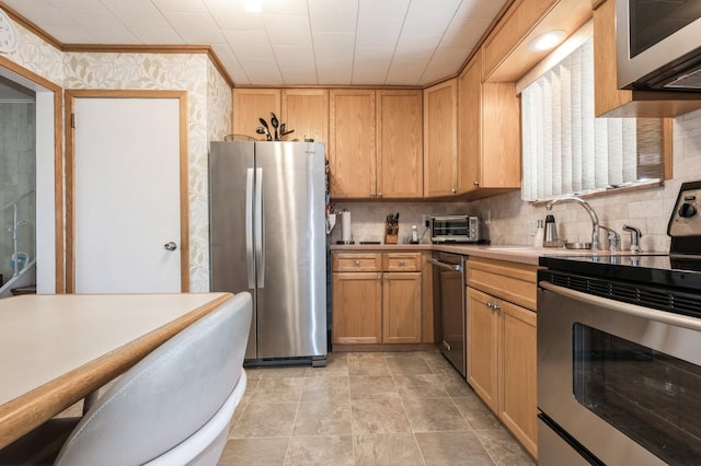 kitchen featuring backsplash, ornamental molding, sink, and appliances with stainless steel finishes