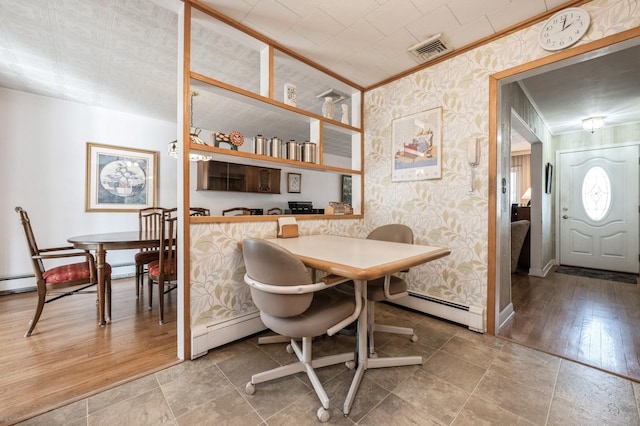 dining room with hardwood / wood-style floors, crown molding, and a baseboard heating unit