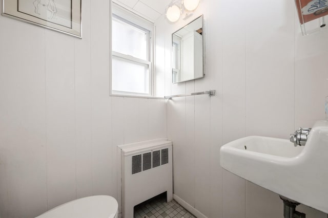 bathroom with toilet, radiator, and sink