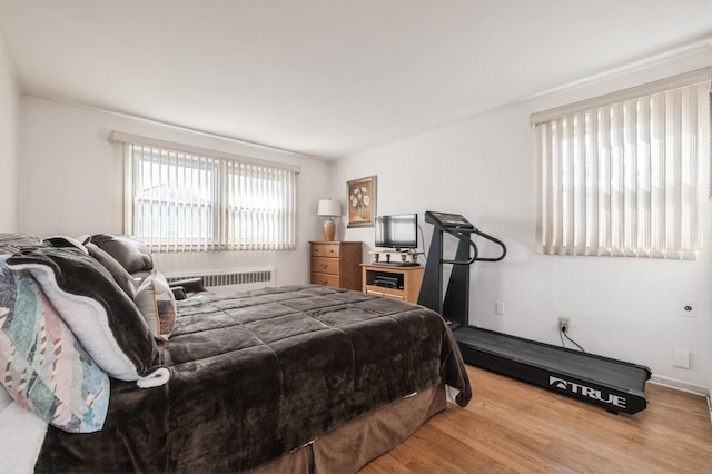 bedroom with radiator and light hardwood / wood-style flooring