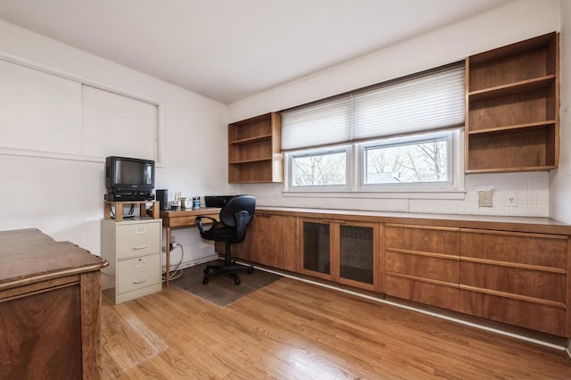 home office with light hardwood / wood-style flooring