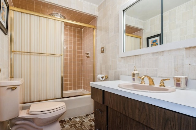 full bathroom with tile walls, vanity, shower / bath combination with glass door, and toilet