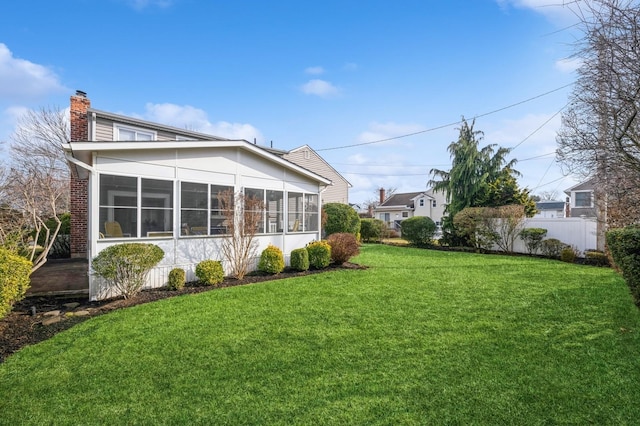 back of house with a lawn and a sunroom