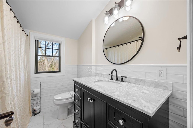 bathroom featuring vanity, lofted ceiling, tile walls, and toilet