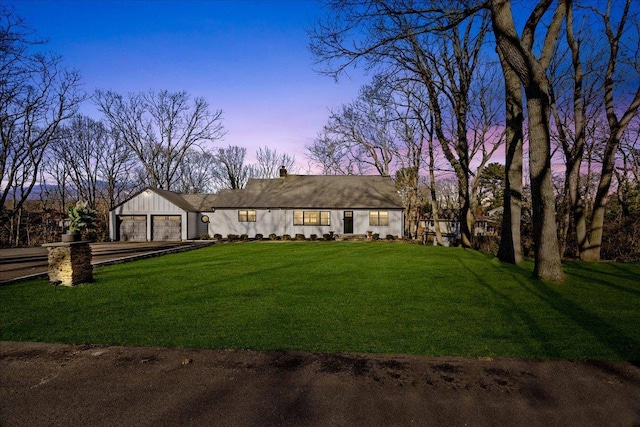 ranch-style house featuring a yard and a garage