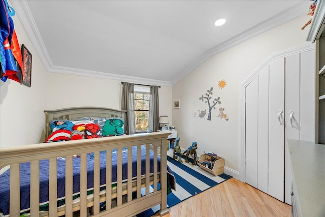 bedroom featuring crown molding and light hardwood / wood-style flooring