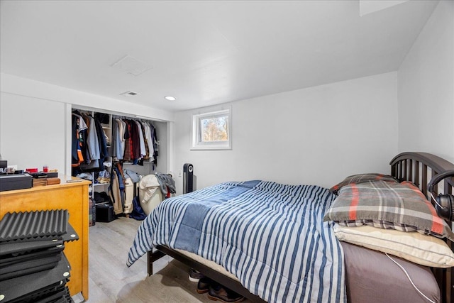 bedroom with light wood-type flooring and a closet