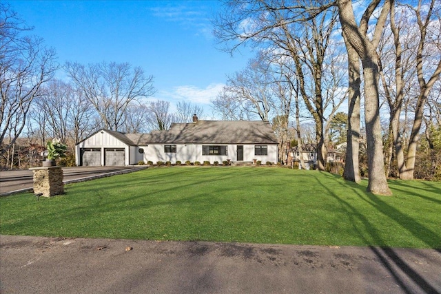 view of front of home with a garage and a front lawn