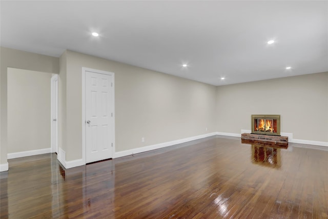 interior space with dark wood-type flooring and a brick fireplace