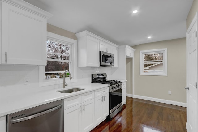 kitchen featuring white cabinetry, appliances with stainless steel finishes, dark hardwood / wood-style flooring, and sink