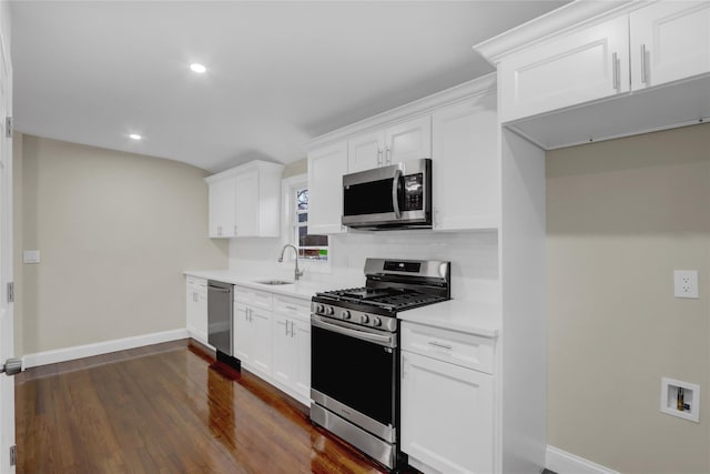 kitchen featuring appliances with stainless steel finishes, sink, white cabinets, and dark hardwood / wood-style floors