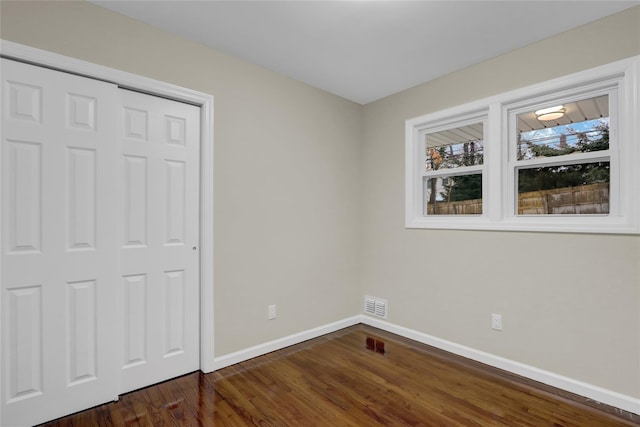 unfurnished bedroom featuring dark hardwood / wood-style flooring