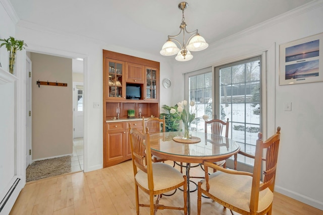 dining area featuring light hardwood / wood-style flooring, ornamental molding, a chandelier, and baseboard heating