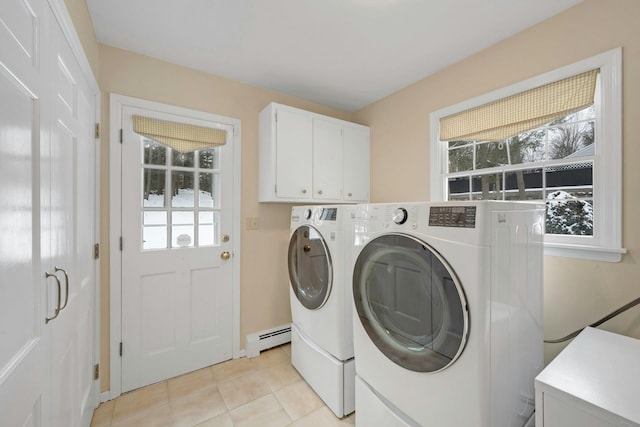 laundry room with baseboard heating, cabinets, washing machine and dryer, and light tile patterned floors