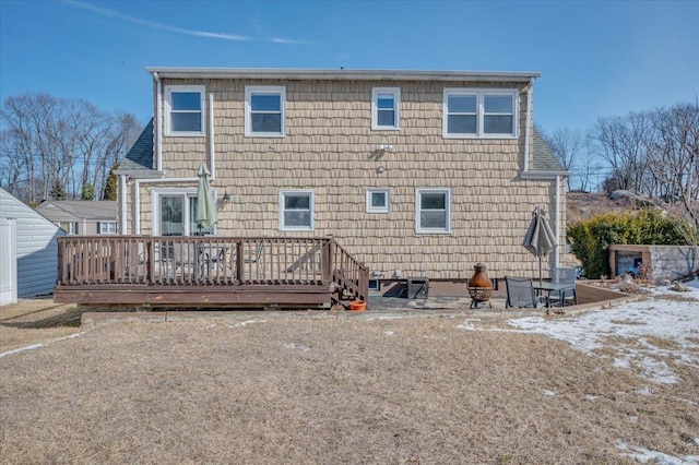 rear view of property featuring a shingled roof and a wooden deck