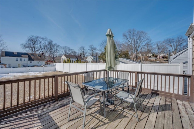 wooden terrace featuring a residential view, outdoor dining area, and a fenced backyard