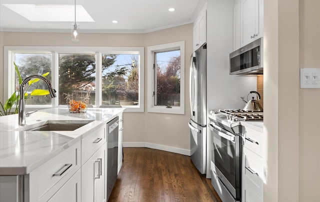 kitchen featuring light stone countertops, white cabinetry, and appliances with stainless steel finishes