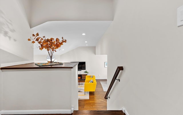 staircase with wood-type flooring and vaulted ceiling