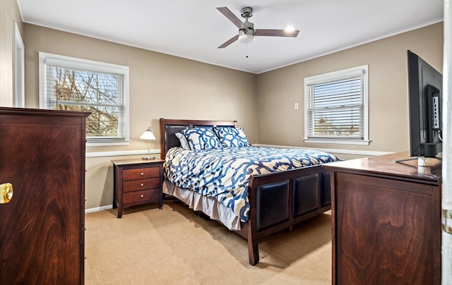 bedroom with multiple windows, light carpet, and ceiling fan