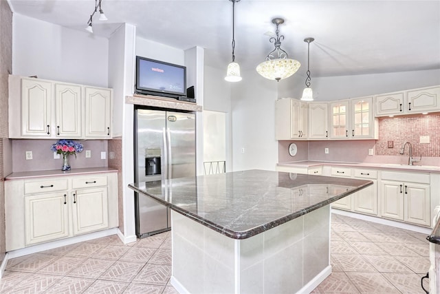28 Robin Hood Rd, Montebello, NY 10901 - kitchen featuring stainless steel refrigerator with ice dispenser, decorative backsplash, lofted ceiling, dark stone counters, and light tile patterned flooring