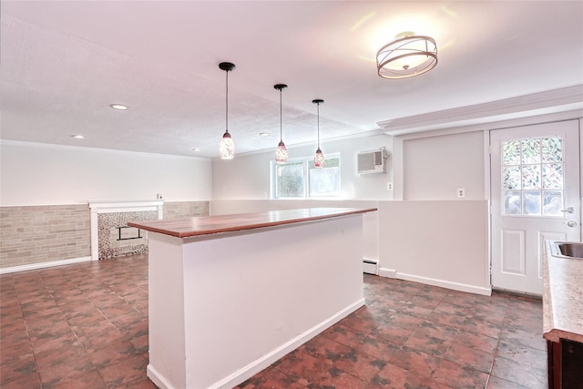 28 Robin Hood Rd, Montebello, NY 10901 - kitchen with an AC wall unit, pendant lighting, a center island, ornamental molding, and a fireplace