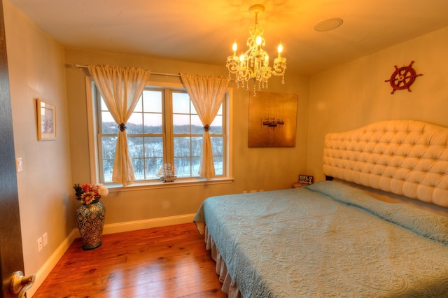 bedroom with wood-type flooring and a notable chandelier