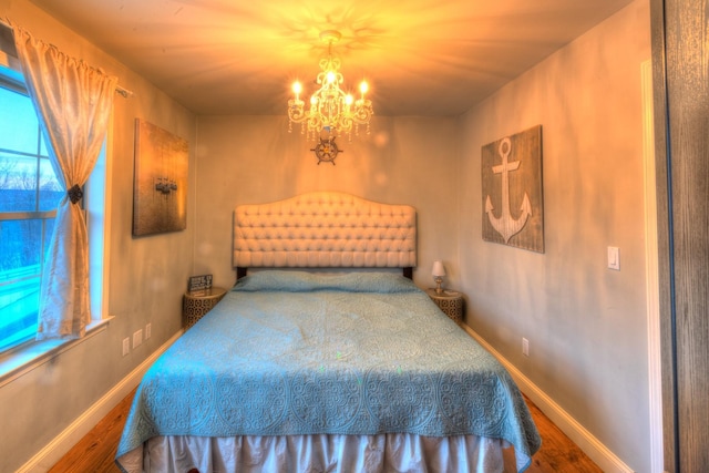 bedroom with hardwood / wood-style flooring and a notable chandelier