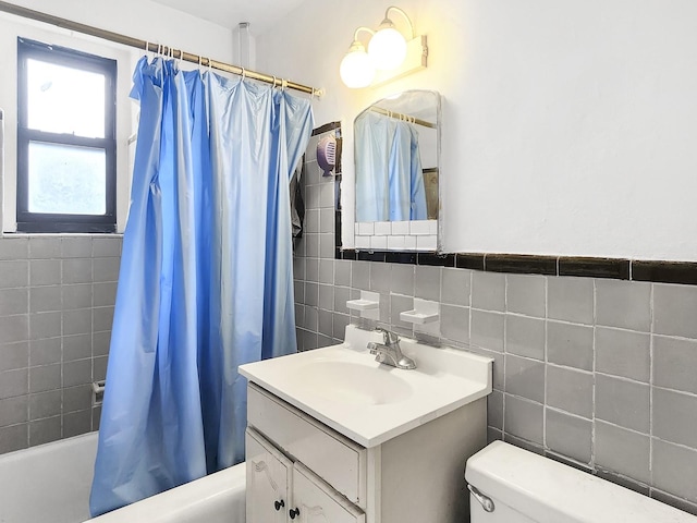 full bathroom featuring shower / tub combo with curtain, vanity, toilet, and tile walls