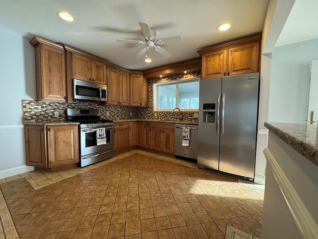 kitchen featuring sink, light tile patterned floors, appliances with stainless steel finishes, ceiling fan, and decorative backsplash